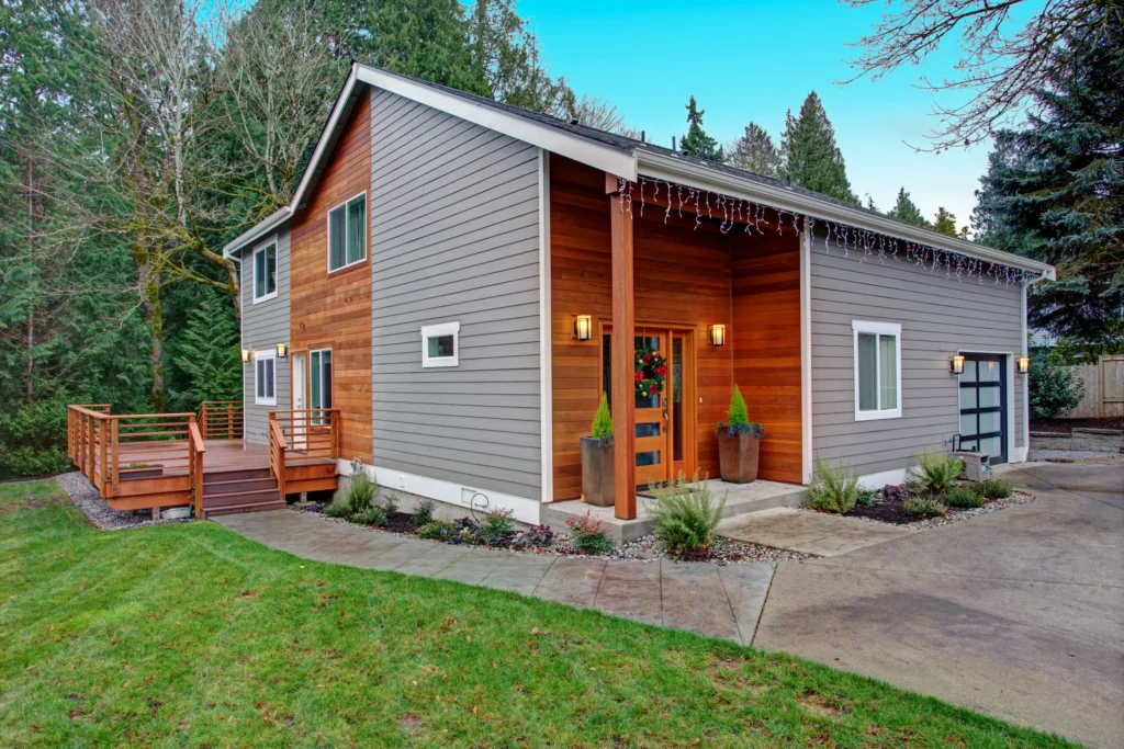 Modern house with wooden deck and driveway.